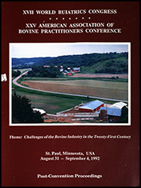 Cover image of the First Volume of the 25th Conference Proceedings: An earl-morning photo of farmland. A small farm is nestled among rolling hills, fields stretching across a curving road that disappears between dark green trees. The barn is a cheery red color with a tin roof. Beneath the photo is the a statement of the conference's theme in white italics: Challenges of the Bovine Industry in the Twenty-First Century. Deep red background.